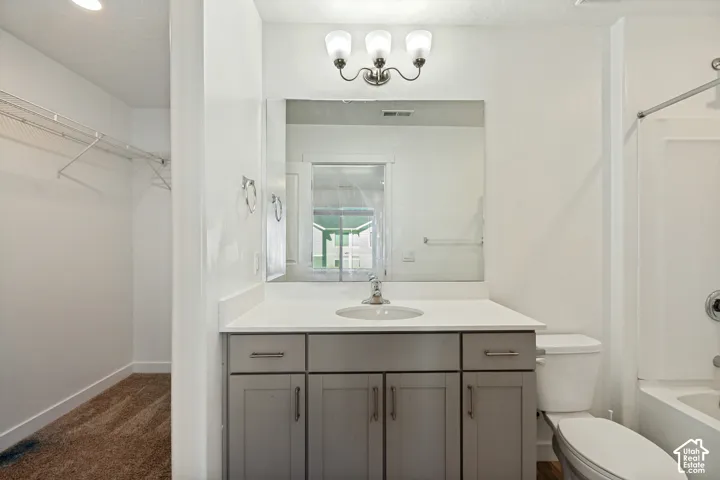 Vanity with light gray cabinetry, white countertop, and integrated sink