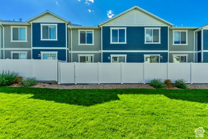 Manicured lawn with a white privacy fence
