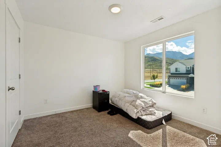Recessed lighting, white walls, carpeted flooring, and a large window