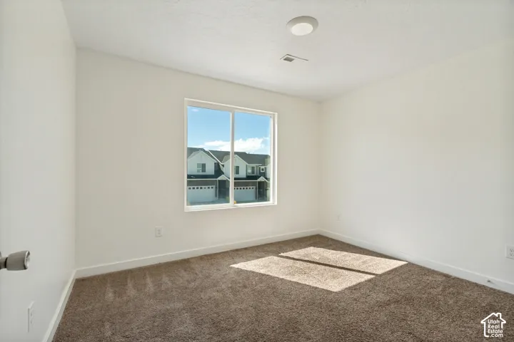 Neutral wall color, recessed ceiling lighting, carpeted flooring, and a large window