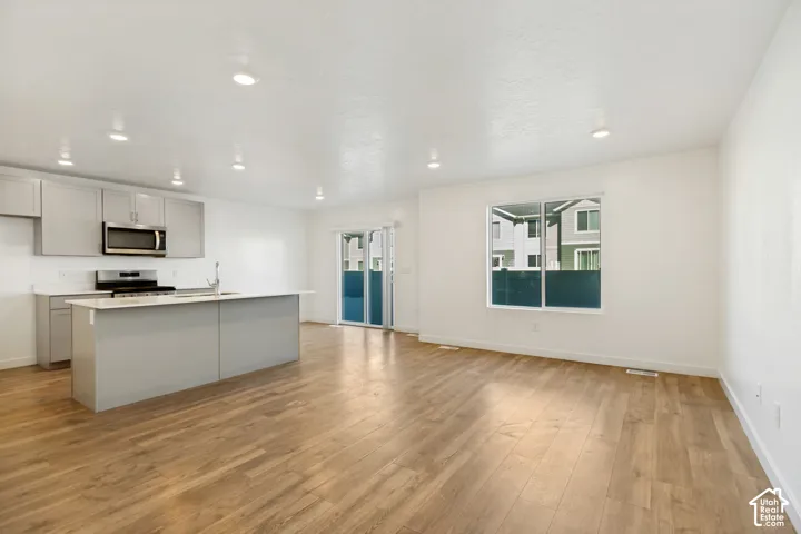 Kitchen with light gray cabinetry, stainless steel appliances, and a central island