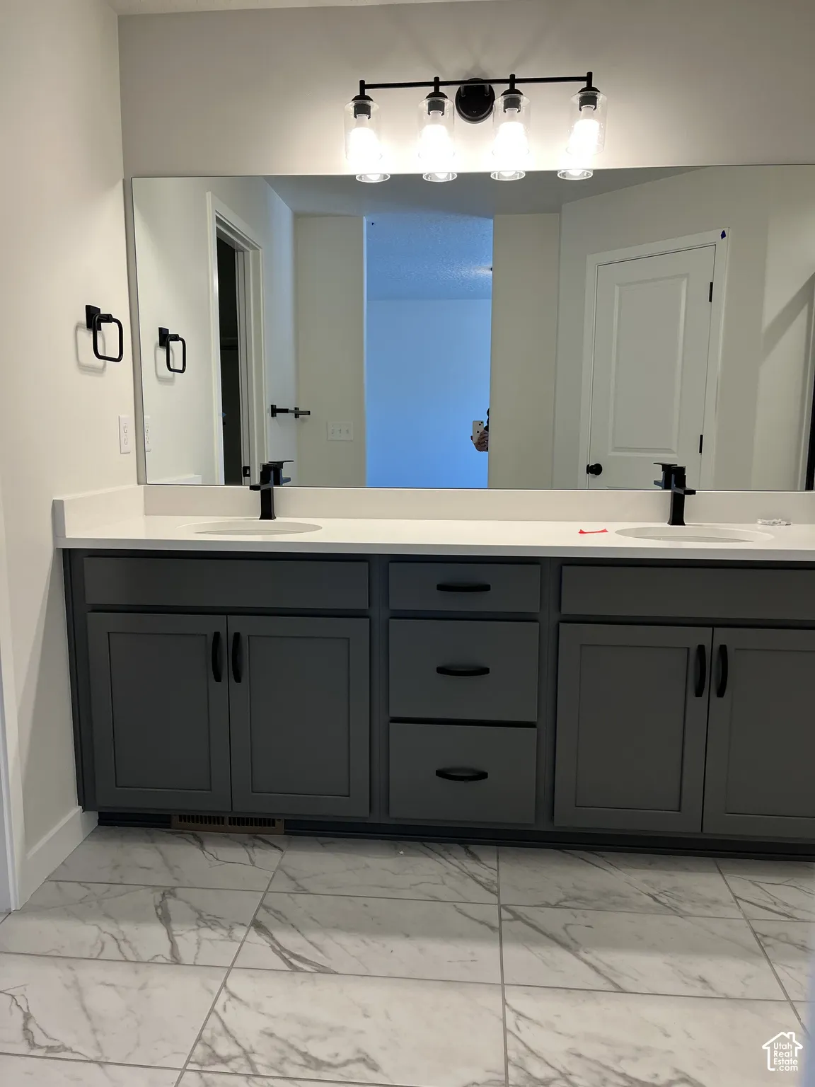 Dual vanity with gray shaker cabinetry and matte black hardware