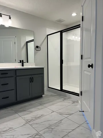 Vanity with a quartz countertop, modern black fixtures, and a large wall-mounted mirror