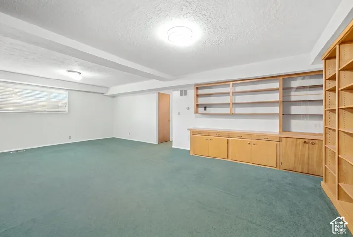 Recessed lighting, wood-finish built-in shelving, wood-finish cabinetry, and a large window
