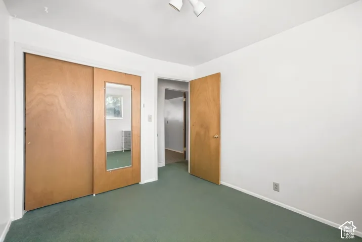 Sliding closet doors with a full-length mirror panel, wood-finish interior door, and overhead track lighting