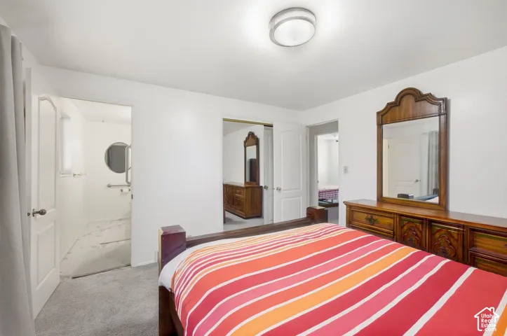 Carpeted flooring with white wall finishes, flush mount ceiling light, and an adjoining room