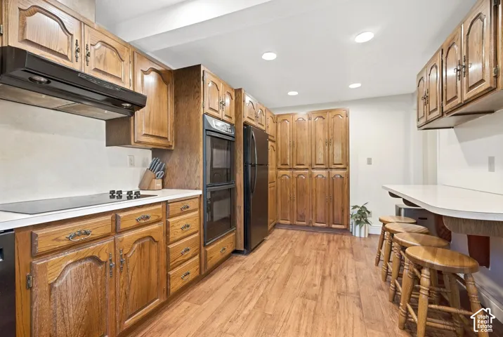 Wood-finish flooring, recessed lighting, built-in double ovens, and extensive cabinetry