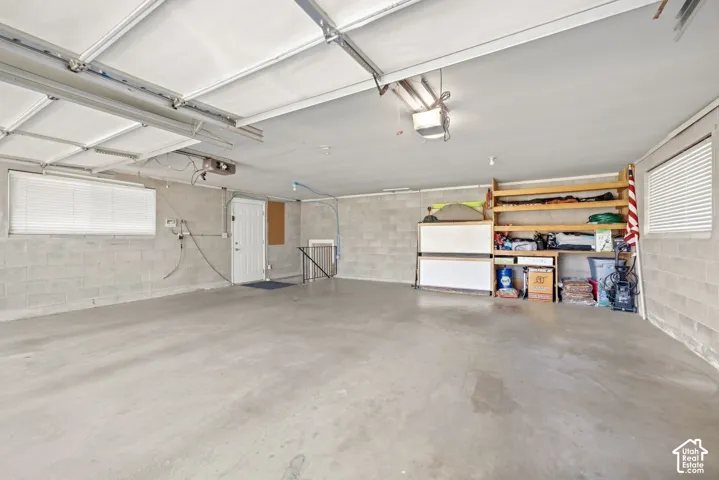 Spacious garage featuring a concrete floor, block walls, and built-in shelving