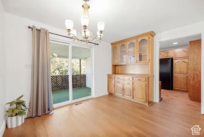 Wood-finish flooring throughout, featuring a built-in wooden hutch with glass-front cabinetry
