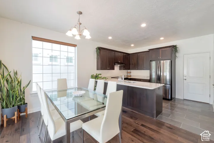 Kitchen featuring dark wood-finish cabinetry, white countertops, stainless steel appliances, and recessed lighting