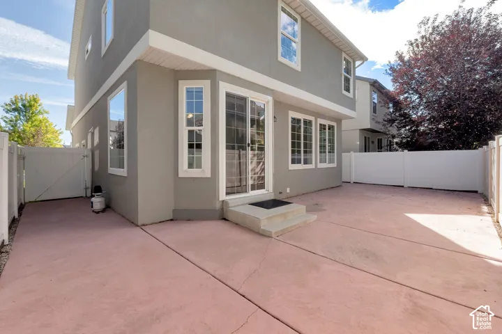 Private fenced patio with concrete surfacing and direct access via sliding glass door