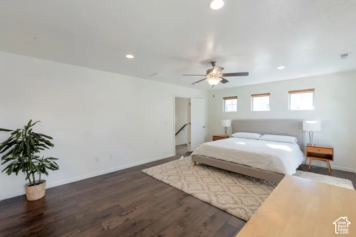 Hardwood-style flooring, recessed lighting, and a ceiling fan are featured in this room with multiple windows
