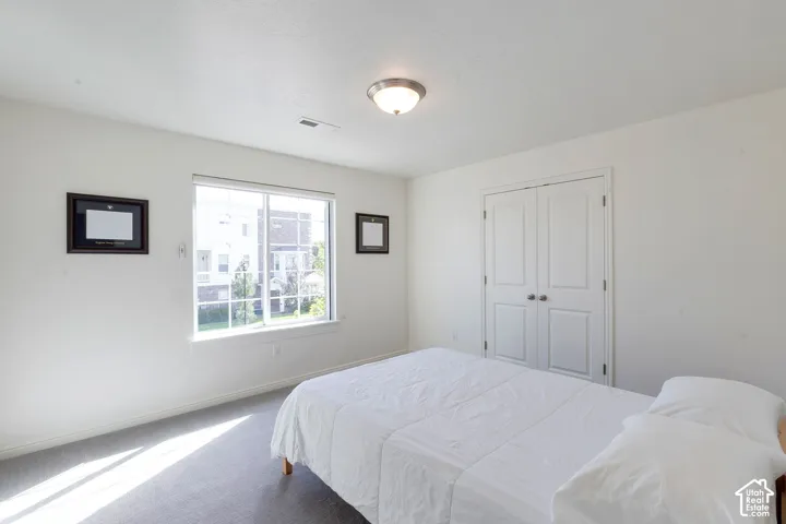 Recessed window with white trim, gray carpet flooring, and white bi-fold closet doors