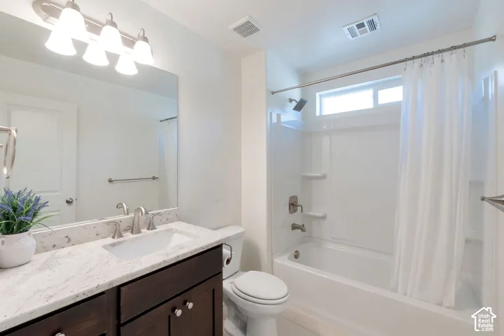 White vanity with a stone-finish countertop and undermount sink