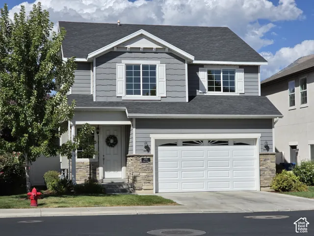 Two-story residence featuring gray siding and stone accents