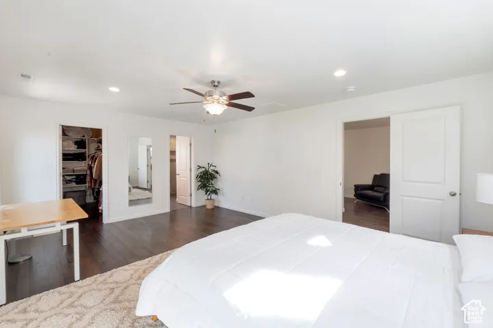 Recessed lighting, dark wood-finish flooring, ceiling fan, and white walls