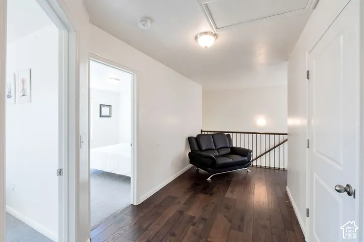 Rich wood-finish flooring, white paneled doors, and wrought iron stair railing