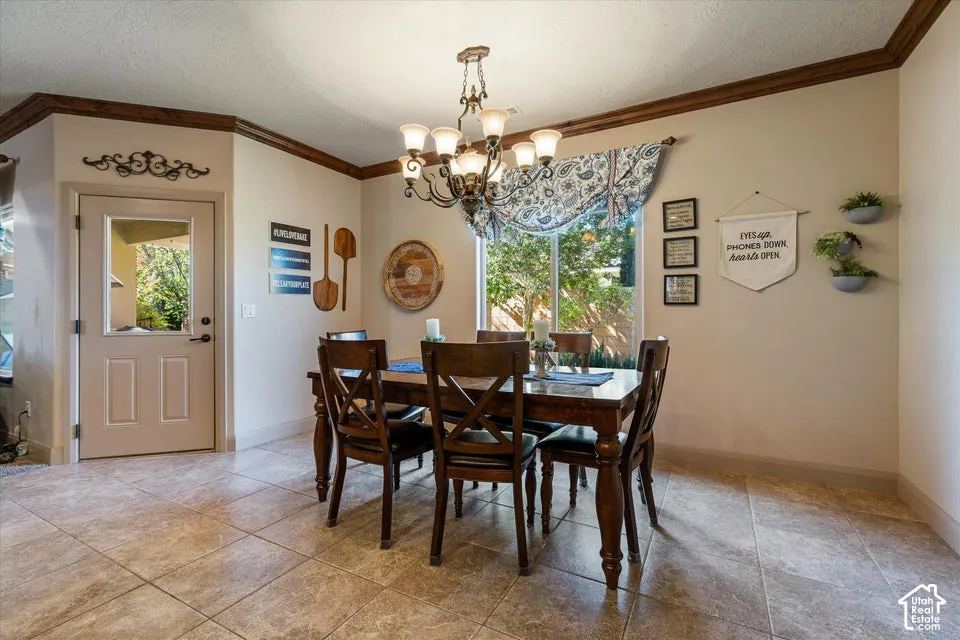 Ceramic tile flooring, crown molding, a decorative chandelier, and a transom window above the exterior door