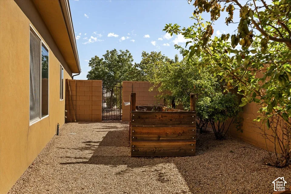 Gravel landscaping with a wood-sided planter box, mature trees, and stucco exterior