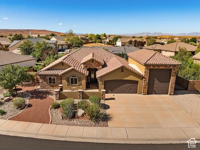 Southwestern-style architecture featuring a tile roof, stucco exterior, and stone accents