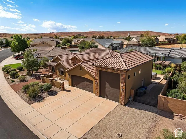 Terracotta tile roof, stucco exterior, stone accents, two-car garage, and desert-adapted landscaping