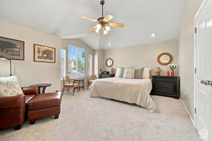 Vaulted ceiling with a ceiling fan, recessed lighting, and expansive windows