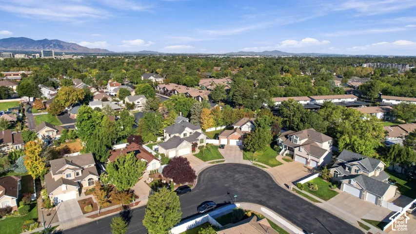 Residential neighborhood with mature trees, a cul-de-sac, and distant mountain ranges