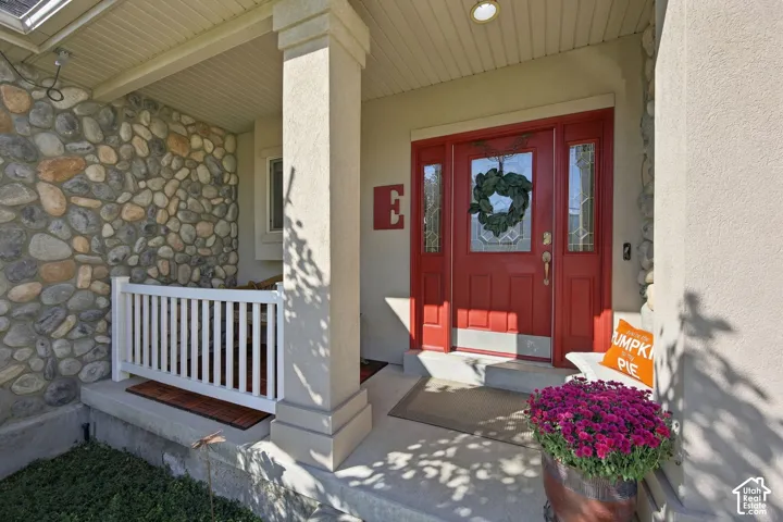 Inviting covered porch with stone accent wall and white railing