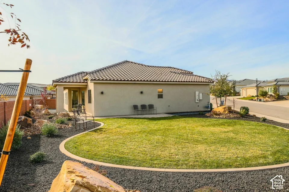 Manicured lawn with concrete curbing, surrounded by dark gravel and rock landscaping