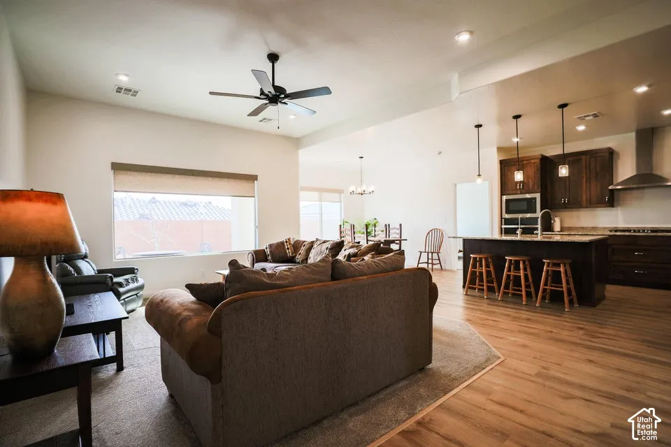 Expansive open-concept living space with wood-finish flooring, recessed lighting, and a ceiling fan