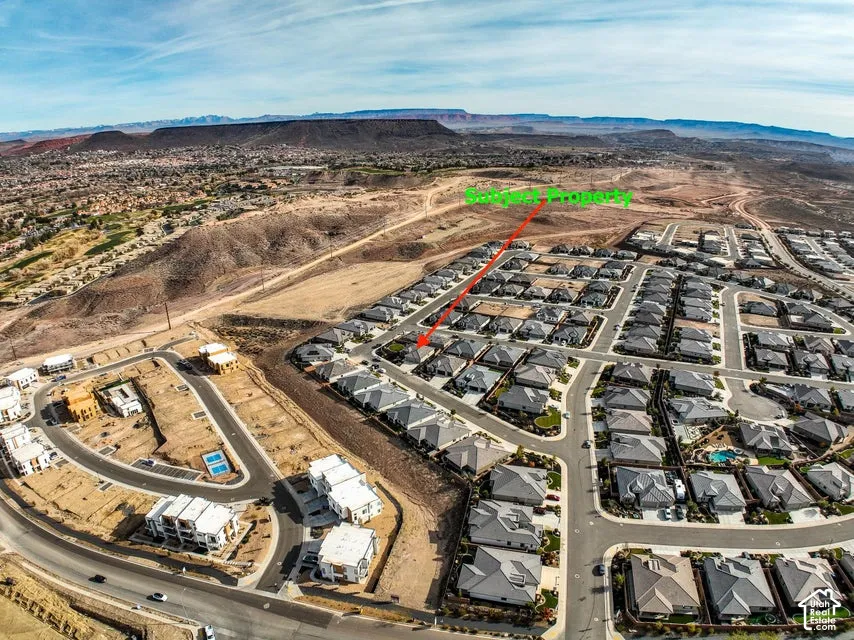 Aerial perspective of a developed residential community with surrounding arid landscapes and distant mountains