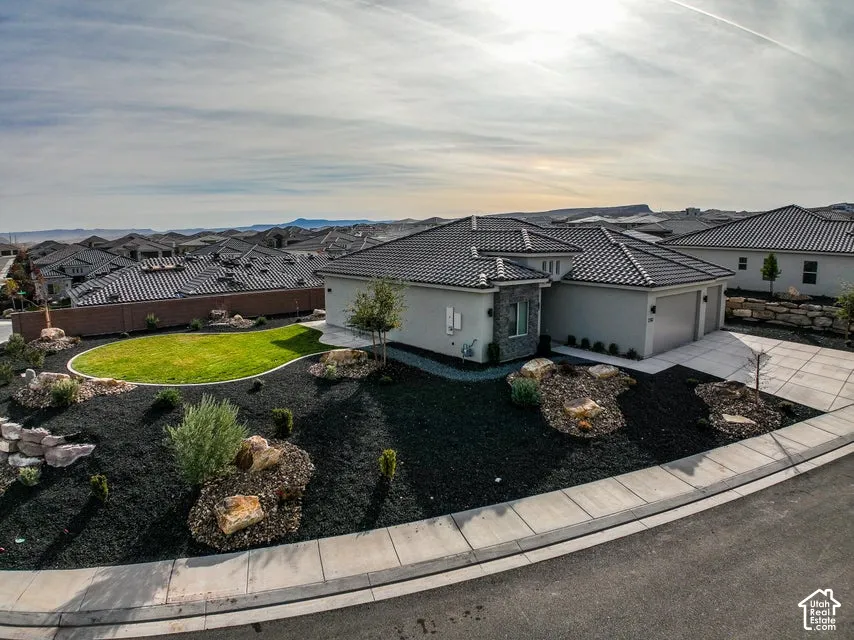 Contemporary exterior with a tiled roof, stone accents, and an attached two-car garage