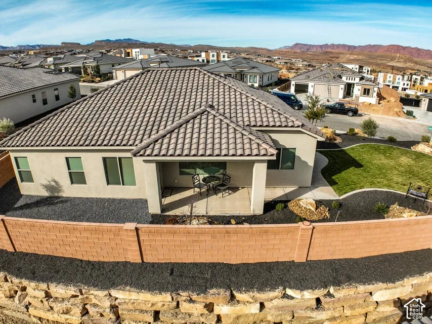 Exterior featuring a tile roof, stucco siding, a covered patio, and a privacy fence