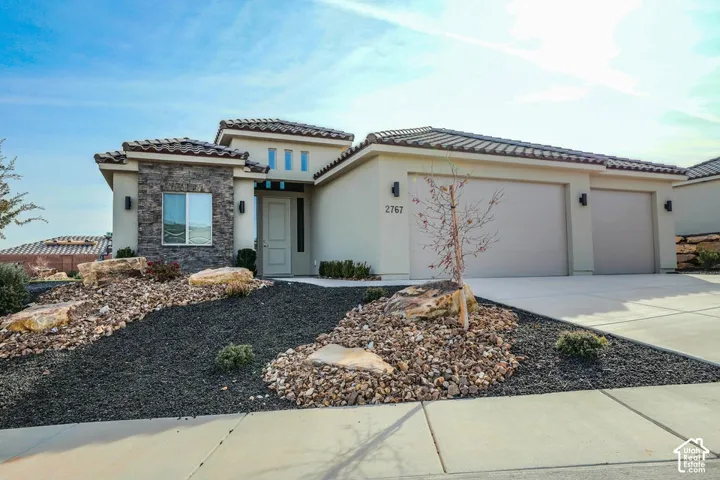 Stucco exterior with stone accent facade, tile roof, and desert-style landscaping
