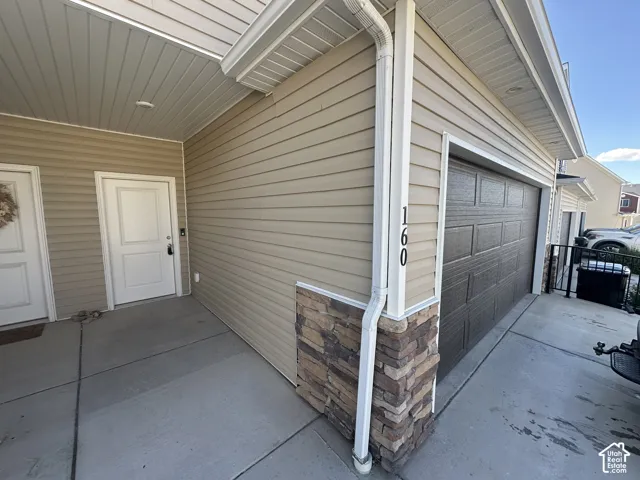 Concrete entry with recessed lighting and a paneled entry door