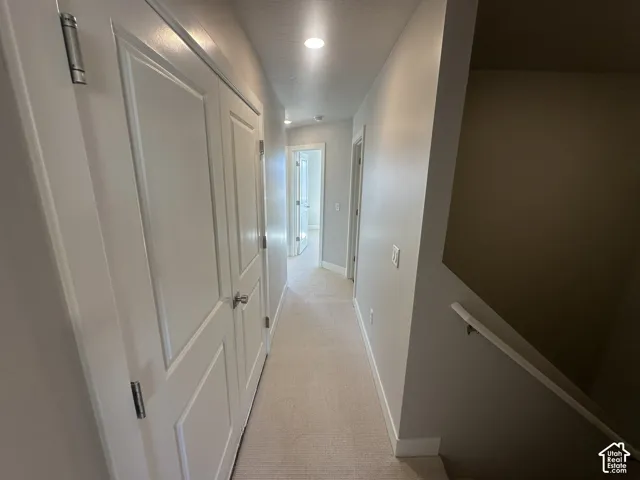 Hallway featuring recessed lighting, paneled doors, light-toned walls, and carpeted flooring