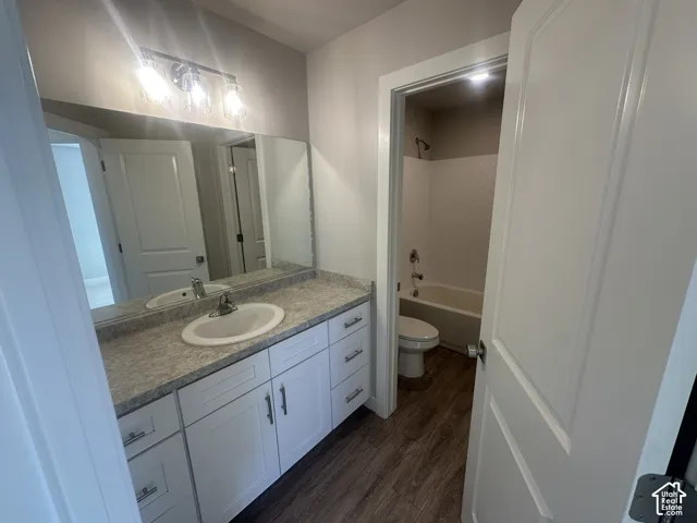 White vanity with ample storage, a spacious countertop, and a large mirror