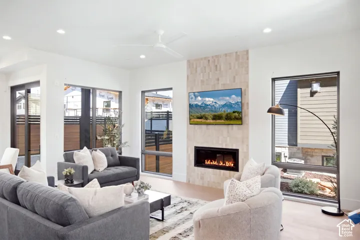 Living area with large windows, recessed lighting, and a modern ceiling fan