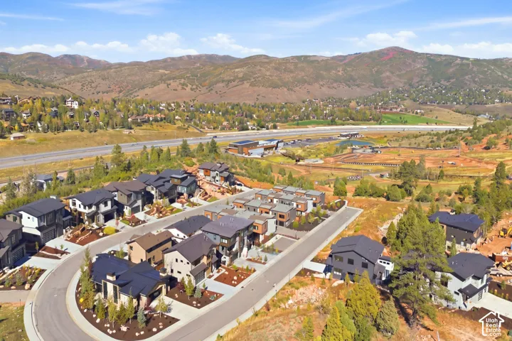 Modern residential development with mountain scenery, paved roadways, and landscaped properties