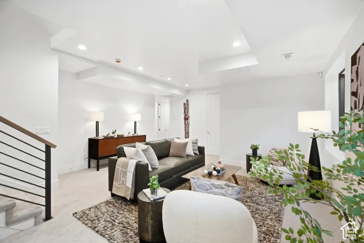 Recessed lighting, wood-finish console, built-in shelving, carpeted flooring, staircase with metal railings