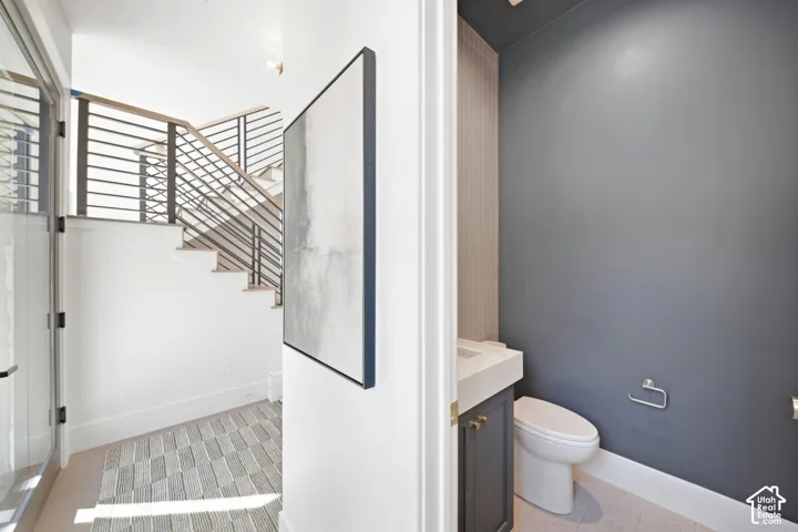 Modern open-riser staircase with horizontal metal balusters and wood handrails