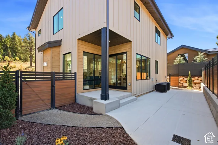 Modern exterior featuring vertical siding, black-framed windows, and a covered patio area