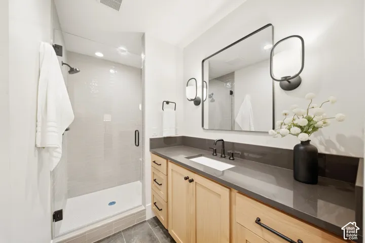 Glass-enclosed shower with tiled walls and a white base