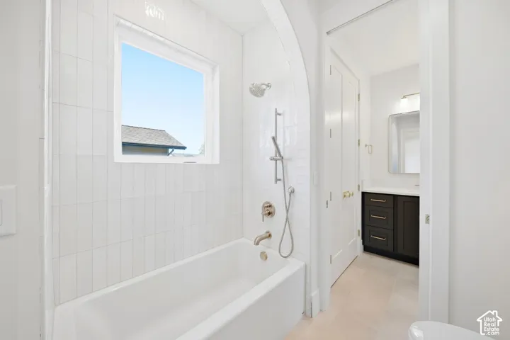 White subway tile shower surround with an integrated bathtub and brushed nickel fixtures