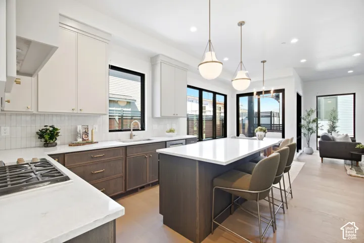 Gourmet kitchen with a gas range, two-tone cabinetry, and a spacious island with seating