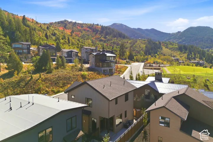 Modern residential architecture with varied rooflines and exterior finishes, surrounded by natural mountainous terrain