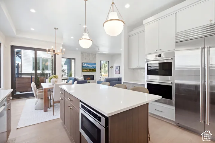 Gourmet kitchen with stainless steel appliances, double ovens, and a large central island with seating