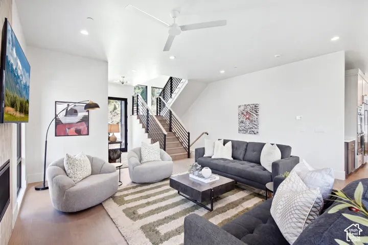 Open-concept living area with wood-finish flooring, recessed lighting, and a modern ceiling fan