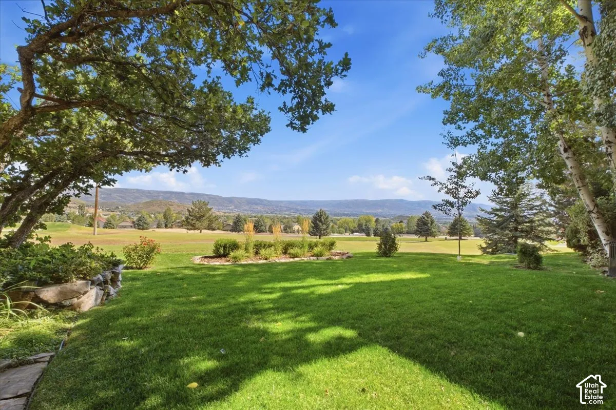 INCREDIBLE views of the valley, golf course, and memorial hill, featuring an expansive manicured lawn with mature shade trees.