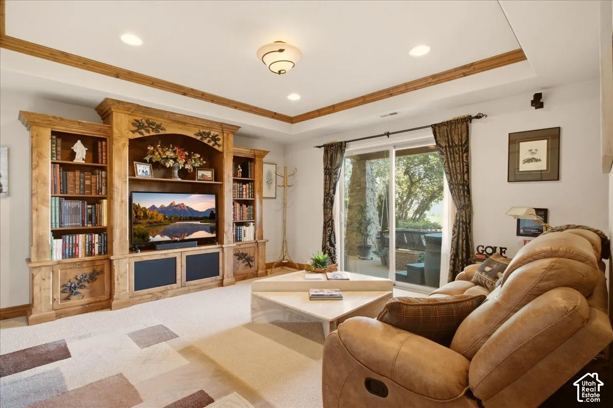 Built-in entertainment center with integrated shelving, recessed lighting, wood-finish ceiling trim, and sliding glass door access to the patio